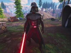 Darth Vader holding a red lightsaber in a forest clearing in Fortnite, from the Epic Games and Disney Star Wars collaboration